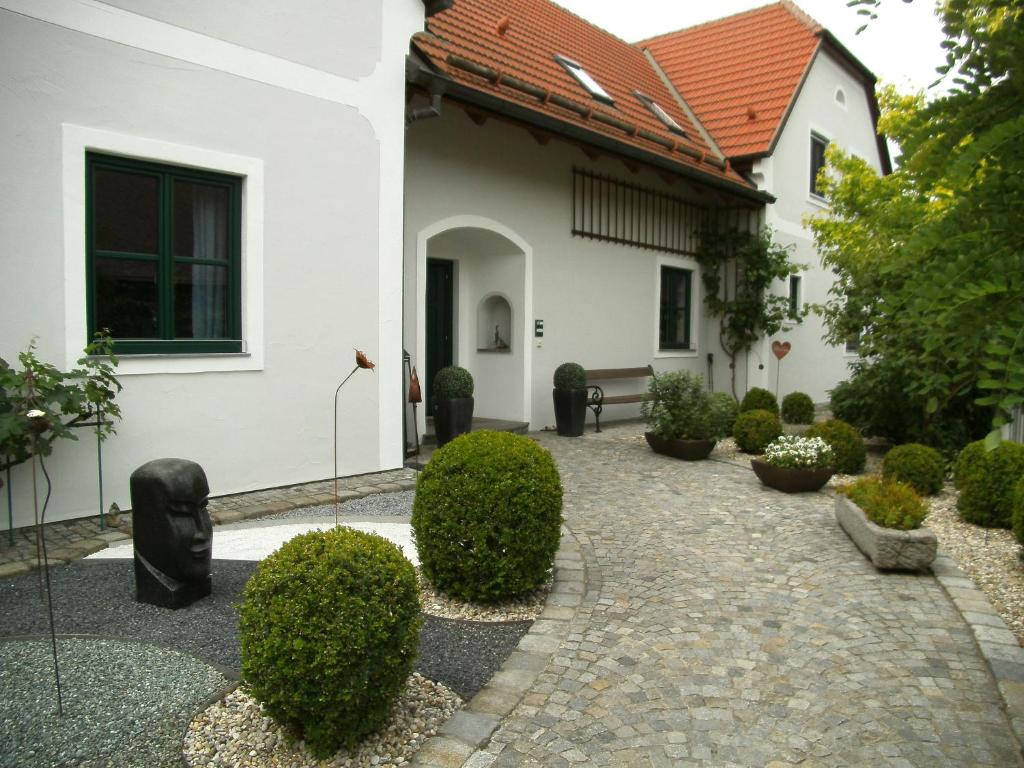 RossatzLandhaus Rossatz的白色房子的庭院,有灌木丛