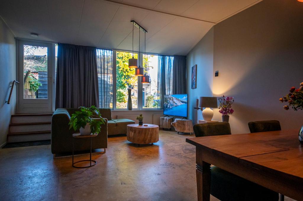 迪弗尔Brinkzicht Diever, appartement Coby的客厅配有桌子和一些椅子