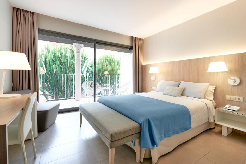 巴塞罗那奥姆尼姆酒店的一间卧室设有一张大床和一个大窗户