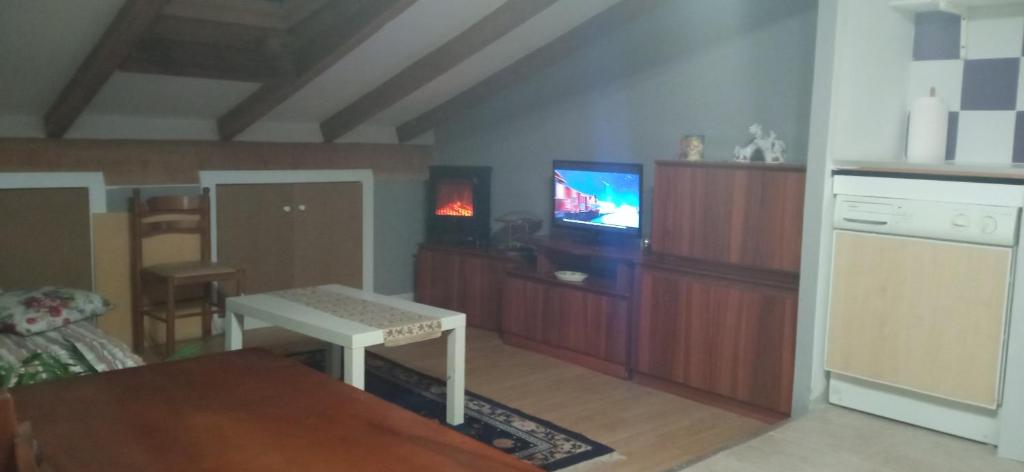 拉瓜迪亚ático的客厅配有桌子和电视。