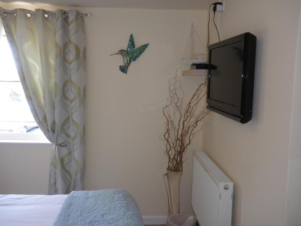 圣萨维尔吉姆塞Longfrie Inn的卧室在床边的墙上配有电视