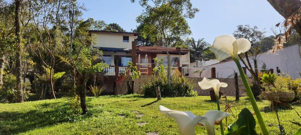 IcatuaçuChácara da Promessa de Deus的前方有白色花的院子的房子