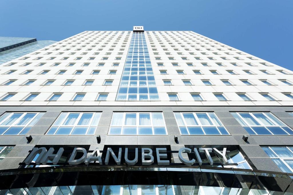 维也纳NH多瑙城酒店的一座高大的建筑,上面有读书的标志