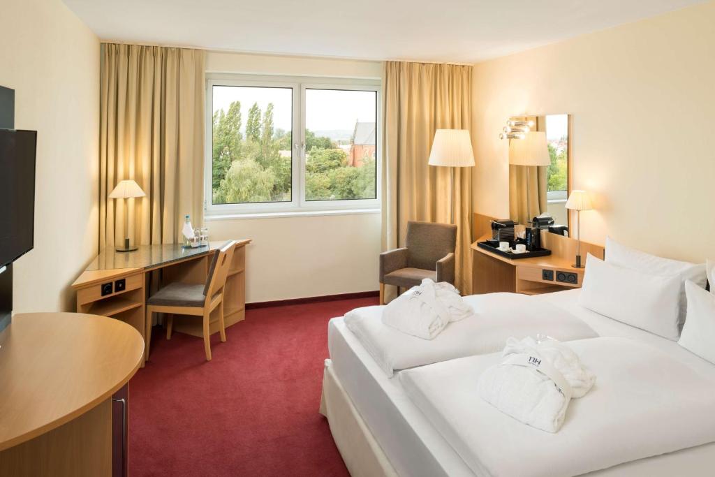 德累斯顿德累斯顿新城NH酒店的配有一张床和一张书桌的酒店客房