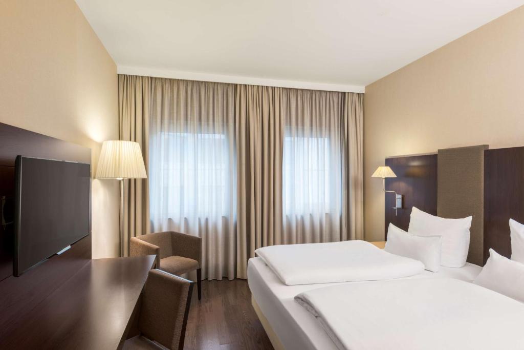 杜塞尔多夫NH杜塞尔多夫国王大道酒店的酒店客房设有一张大床和一台电视。