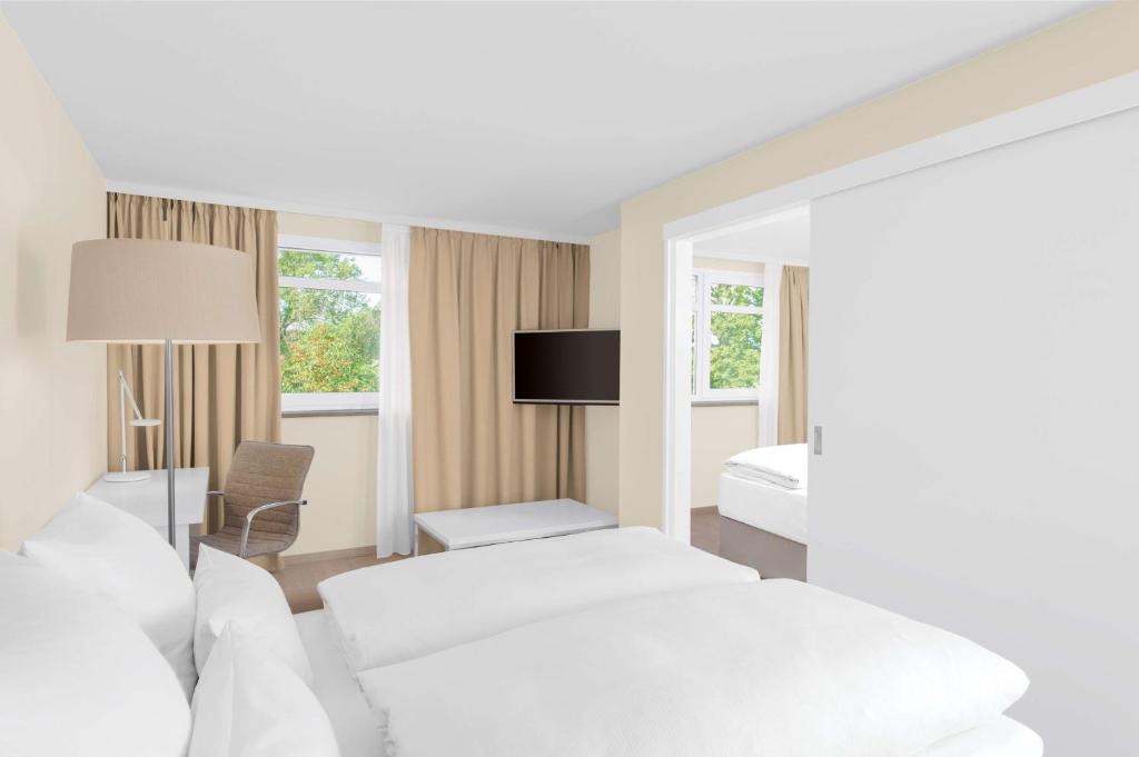 菲尔特菲尔特纽伦堡NH酒店的酒店客房,配有两张床和椅子