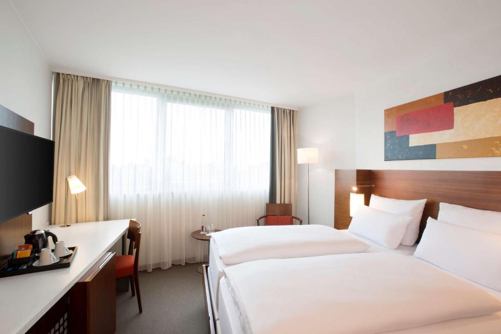 美因河畔法兰克福弗兰克福特涅得拉德NH酒店的酒店客房配有两张床和一张书桌