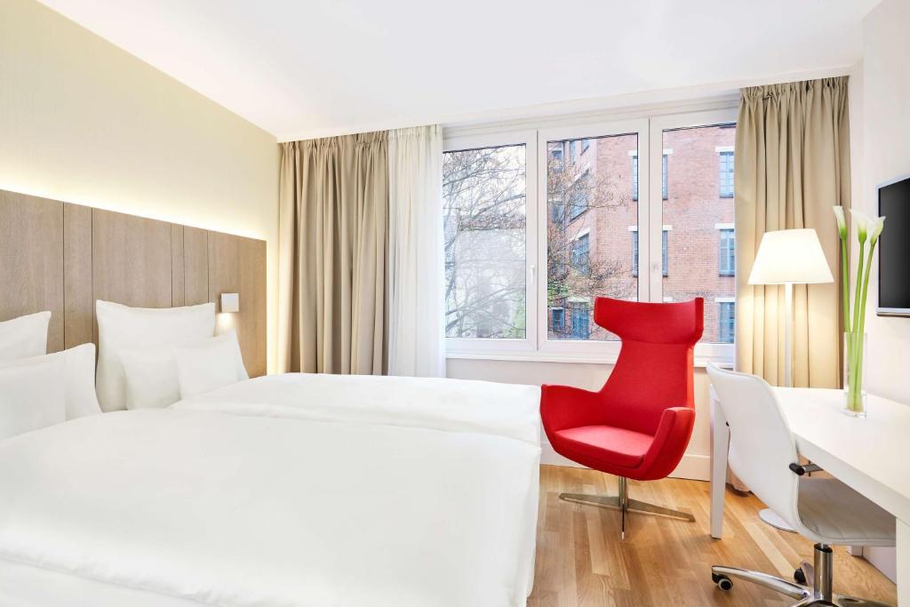 汉堡汉堡市NH系列酒店的酒店客房带白色的床和红色椅子