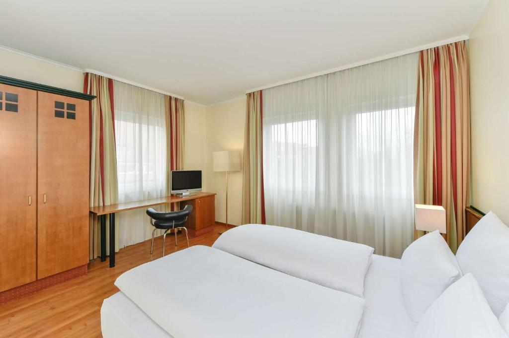 慕尼黑NH慕尼黑苏德酒店的酒店客房配有两张床和一张书桌