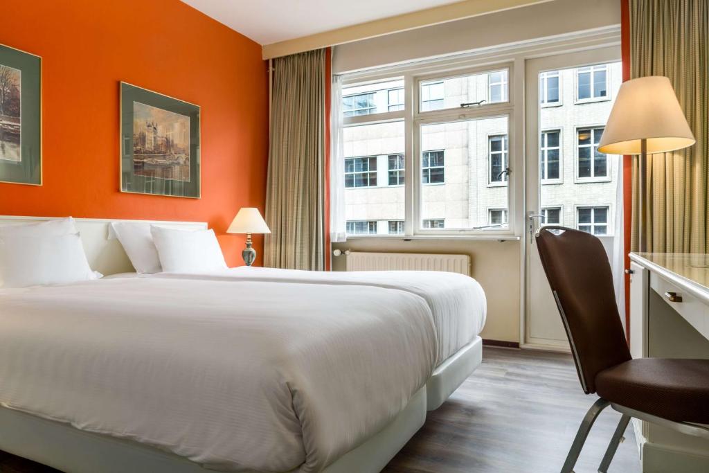 鹿特丹鹿特丹亚特兰大NH酒店的一间设有大床和窗户的酒店客房