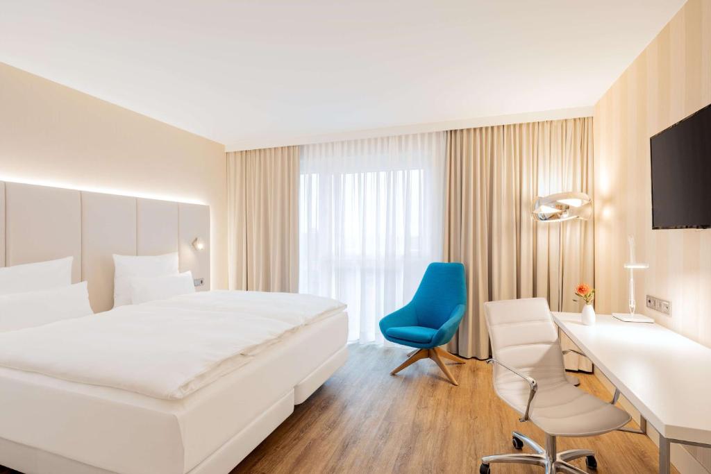 曼海姆NH Mannheim的酒店客房带大床和蓝椅