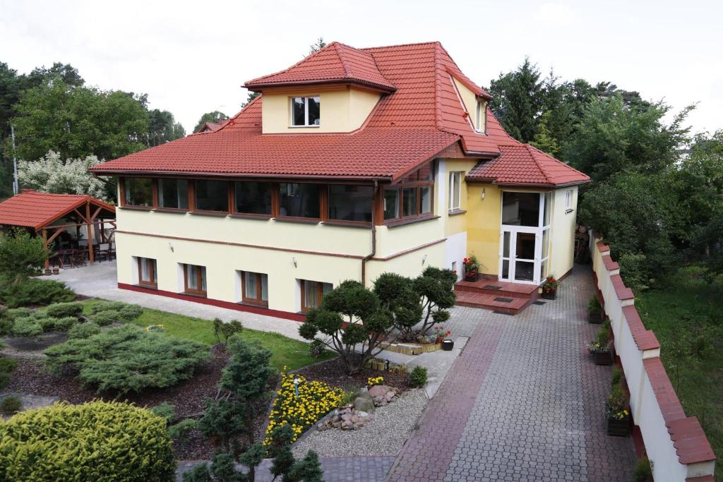 比得哥什威拉马克西米利安住宿加早餐旅馆的一座红色屋顶的房子和一个花园