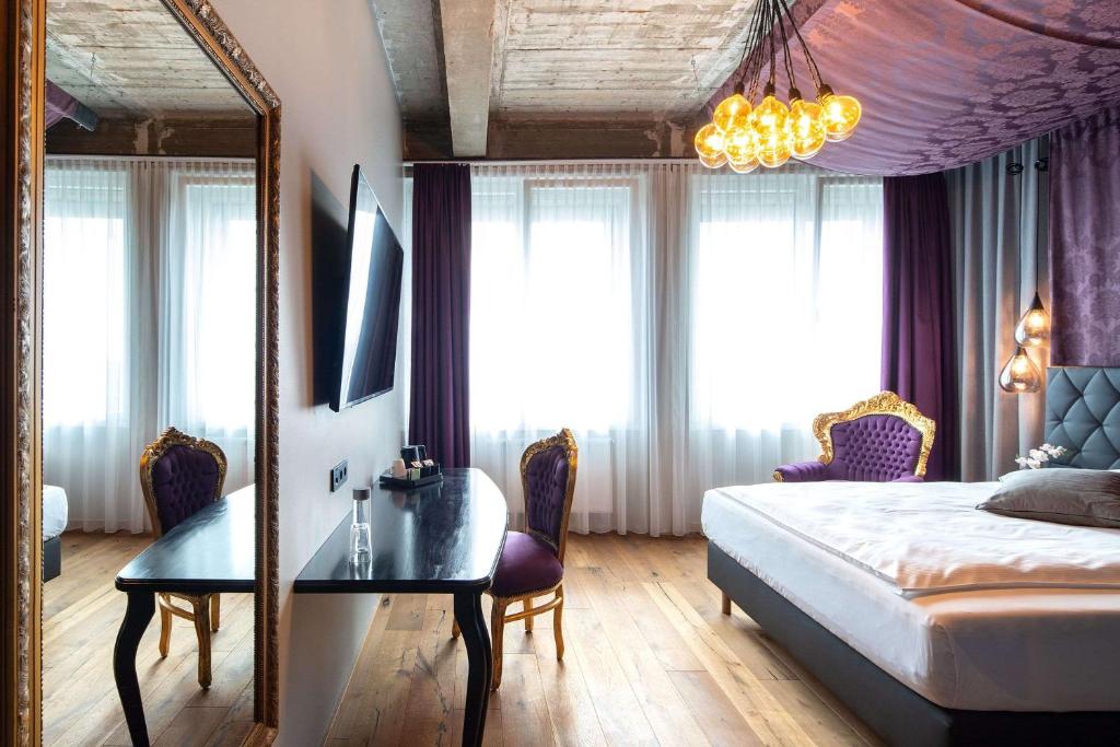 汉诺威LOFTSTYLE Hotel Hannover, Best Western Signature Collection的一间卧室配有一张床、一张桌子和一面镜子