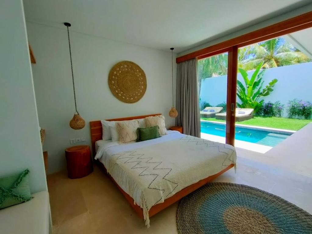 龙目岛库塔Kalea Villas的一间卧室设有一张床,享有游泳池的景色