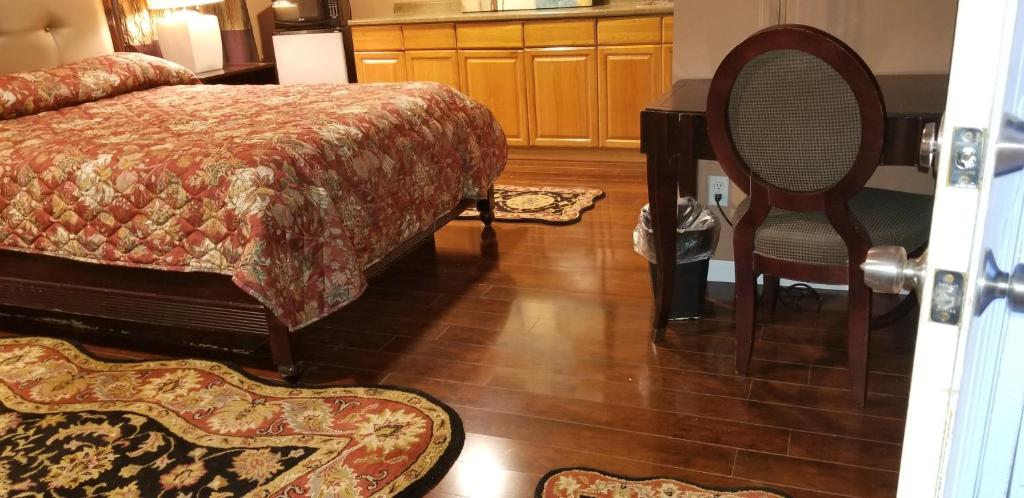 南安普敦Sea Haven Resort Motel的一间卧室配有一张床和一把椅子,铺有木地板