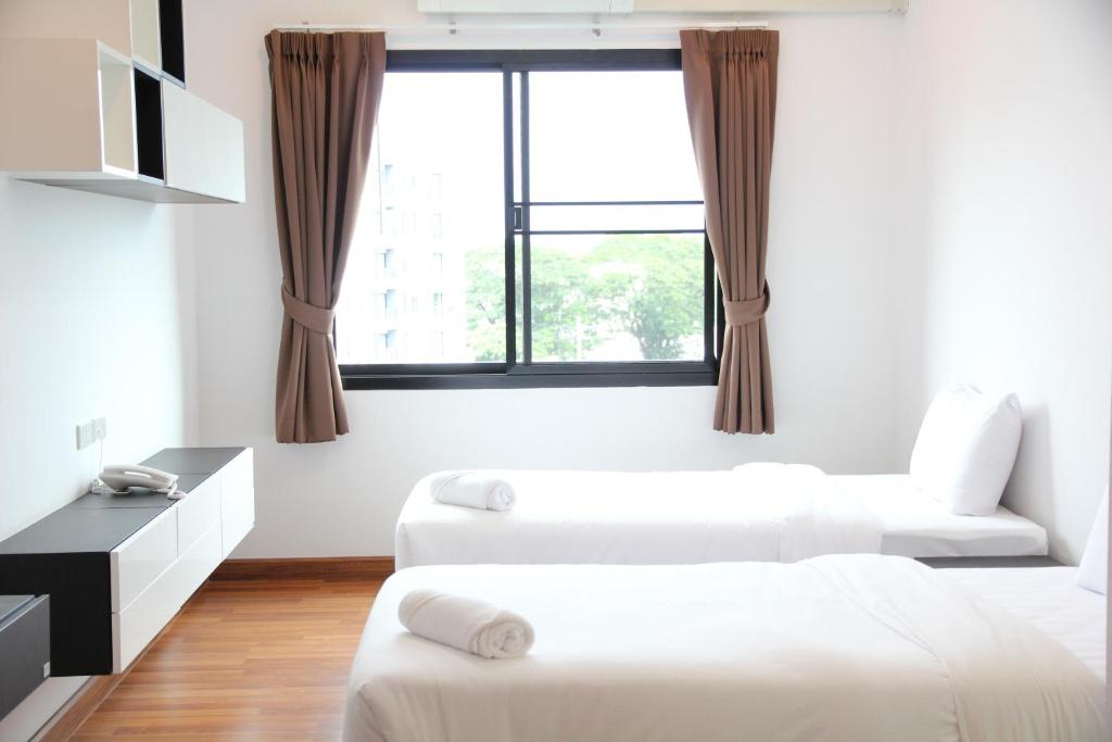 清迈V-twin Donjan Service Apartment的一间带两张床和窗户的客厅