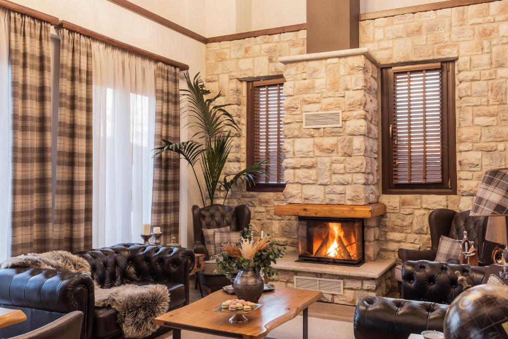 约阿尼纳MONTANA LAKE VIEW的客厅配有皮革家具和壁炉