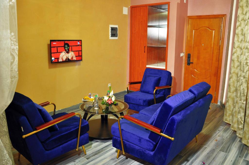 雅温得Hôtel Sindz Palace的一间设有蓝色椅子和桌子的等候室
