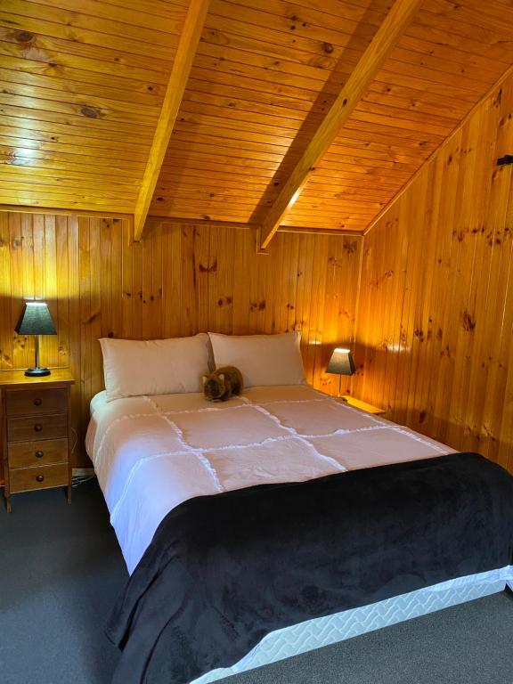 TullahThe Wombat Cottage的卧室设有一张木制天花板上的大床