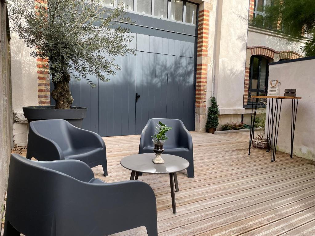 旺德夫尔莱南锡Maison d'hotes L'atelier du Charmois的一个带椅子和桌子的庭院和一个蓝色的车库门
