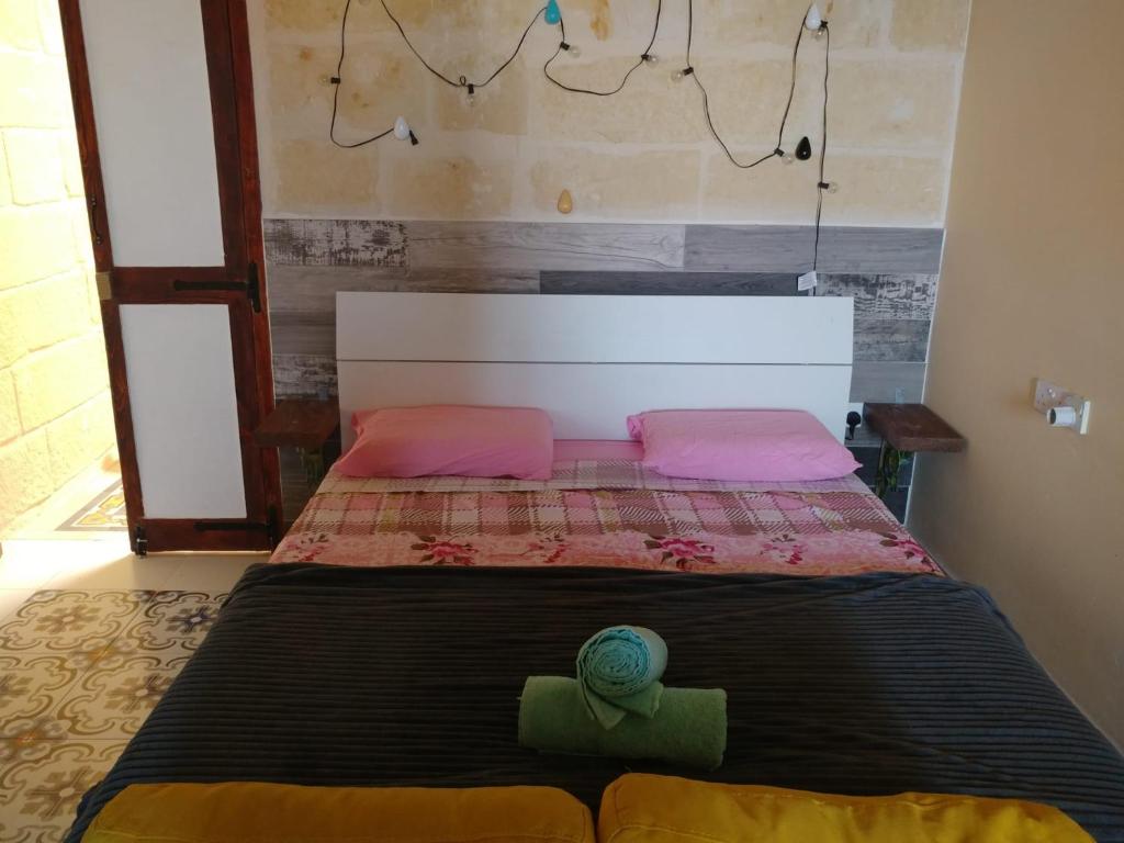 维多利亚Triesti Home的一张带粉红色和绿色枕头的床