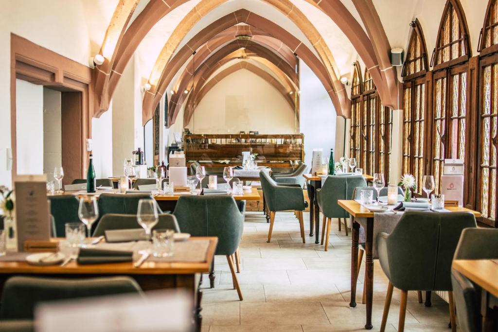 特里尔Boutiquehotel Kloster Pfalzel的餐厅设有木桌和绿色椅子