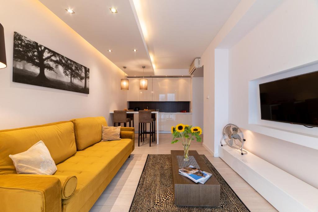 华沙铂金大厦E公寓的客厅配有黄色的沙发和桌子
