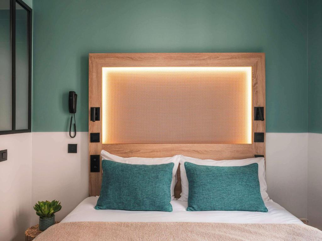 巴黎宜必思巴黎蒙马特尔北酒店的一间卧室配有一张带床头板的床和两个枕头