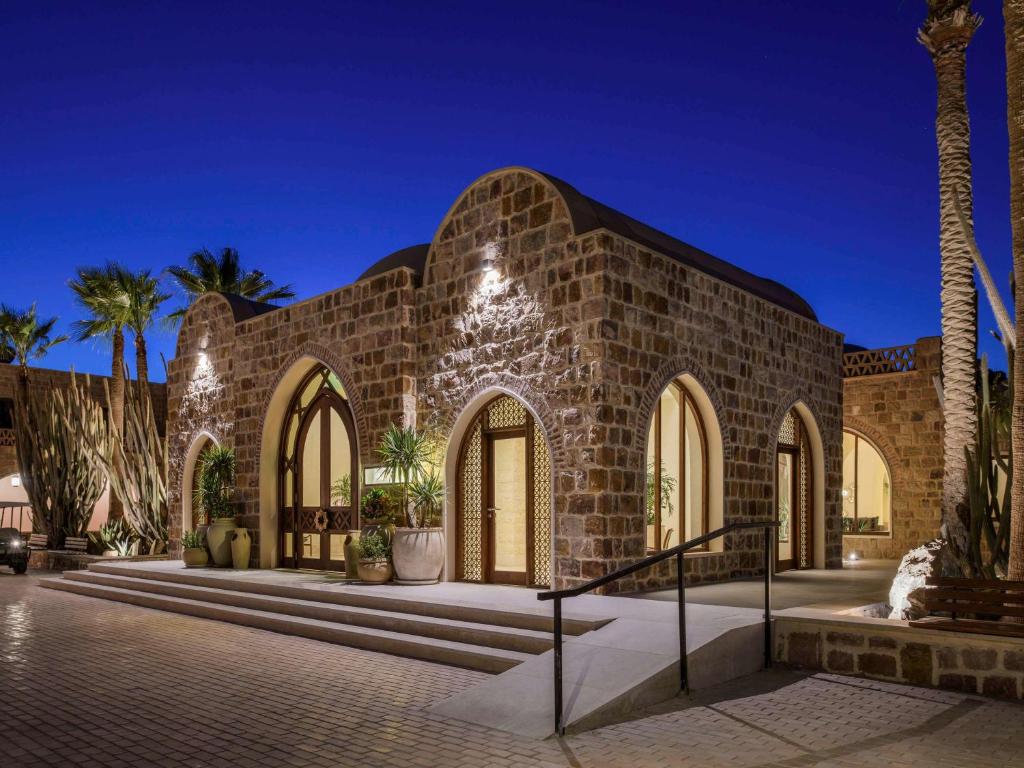 库塞尔Movenpick Resort El Quseir的一座棕榈树掩映的砖砌建筑