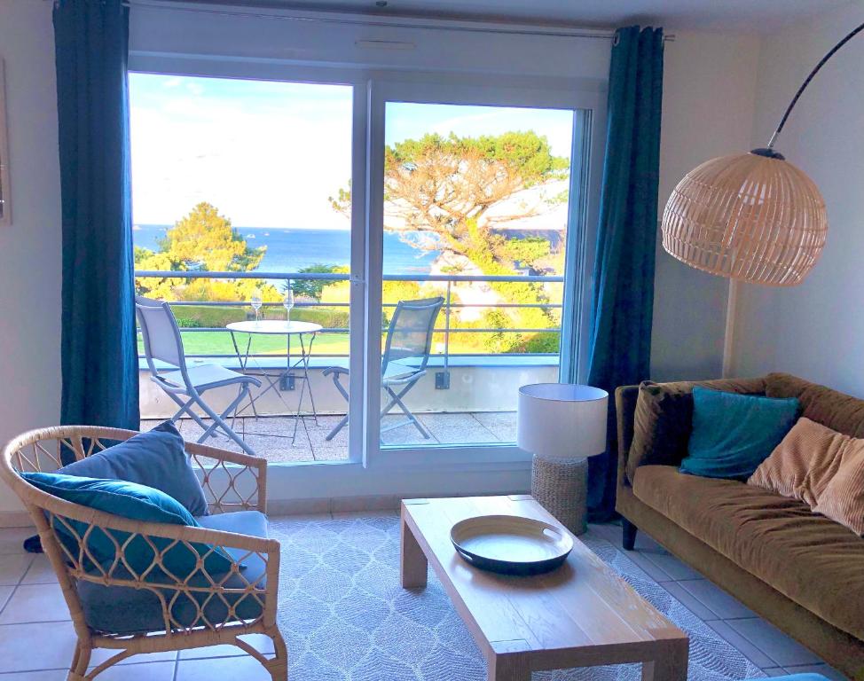 卡朗泰克Appartement vue mer à 100m de la plage au centre de Carantec的带沙发的客厅,享有海景