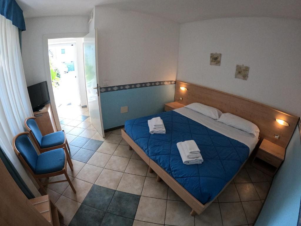 Staranzano阿尔贝格拉卡拉维拉酒店的一间卧室配有蓝色的床和椅子