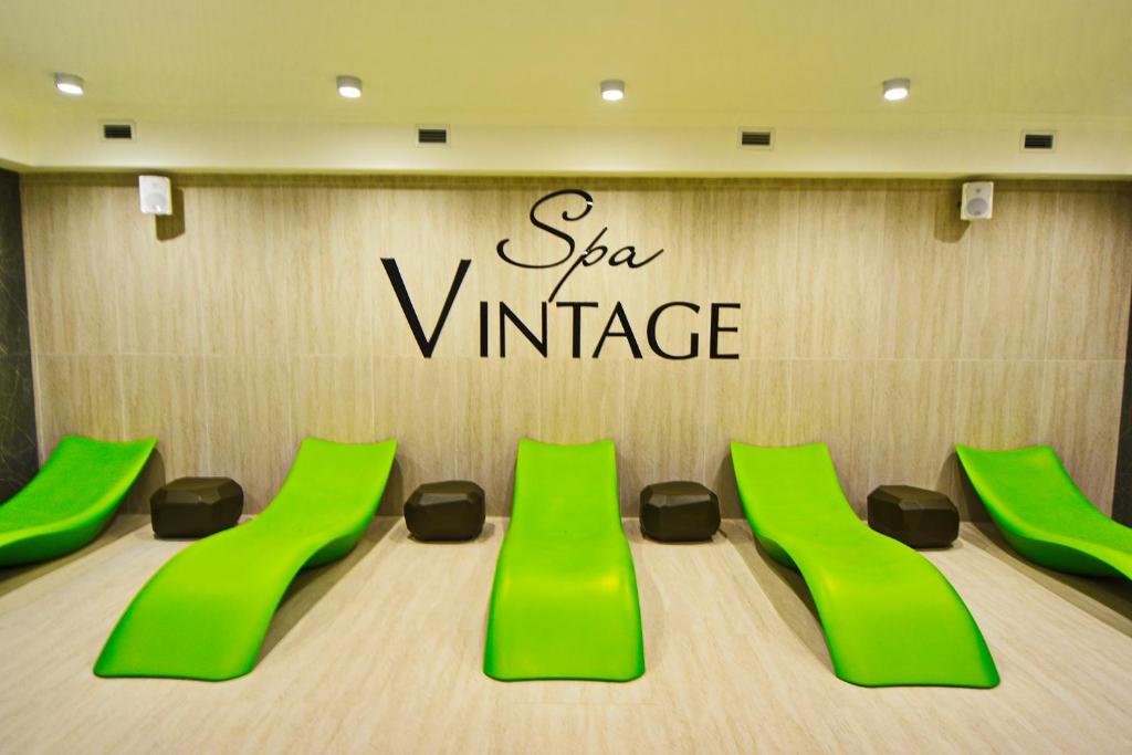 阿纳帕Spa Hotel "VINTAGE"的一间会议室,配有绿色椅子和标志