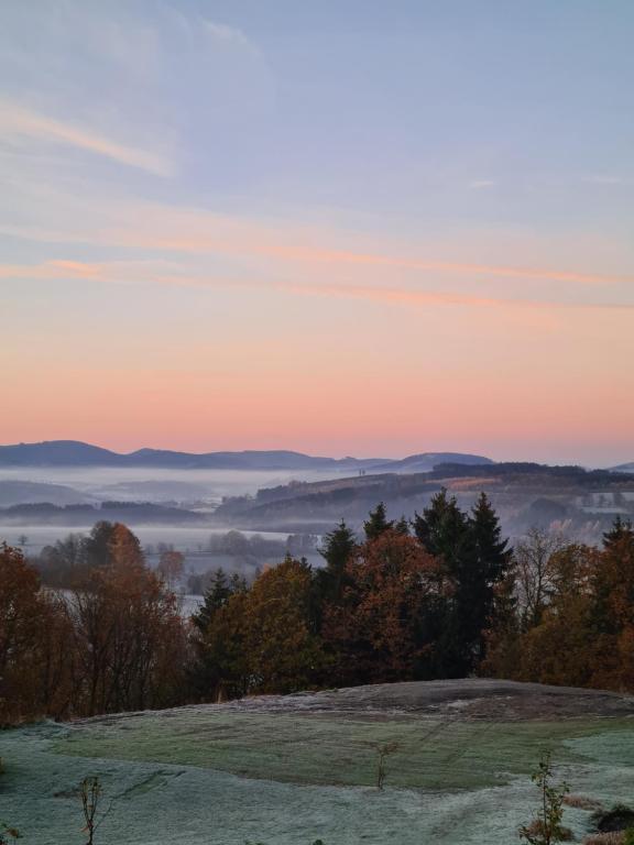 施马伦贝格Ferienwohnung Hennemann的日落时分享有雾 ⁇ 的山谷美景