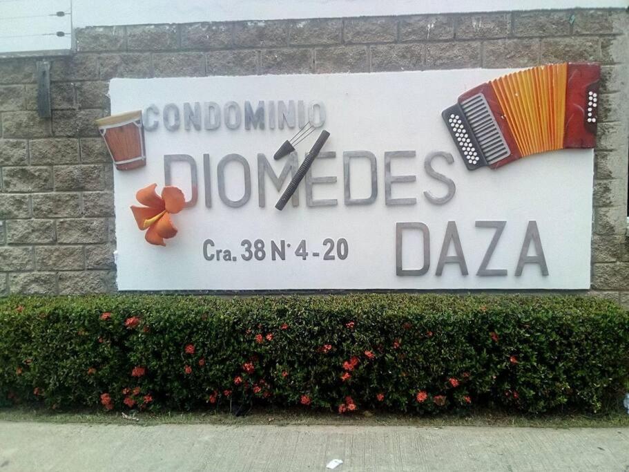 巴耶杜帕尔Casa Condominio Diomedes Daza Valledupar的建筑上装饰着白 ⁇ 花的标志