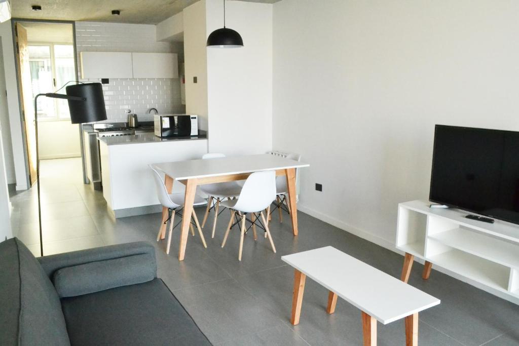 内乌肯Loi Flats Edificio Tucuman的一间带桌椅的客厅和一间厨房