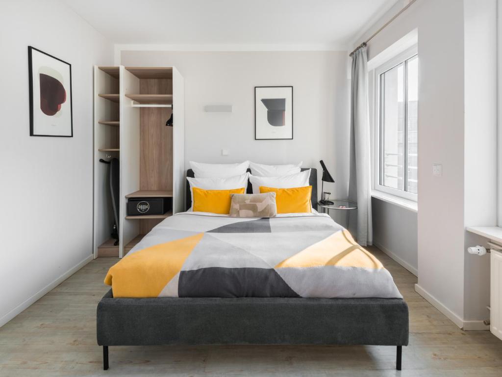 美因河畔法兰克福numa I Blau Apartments的一间卧室配有一张带黄色枕头的大床