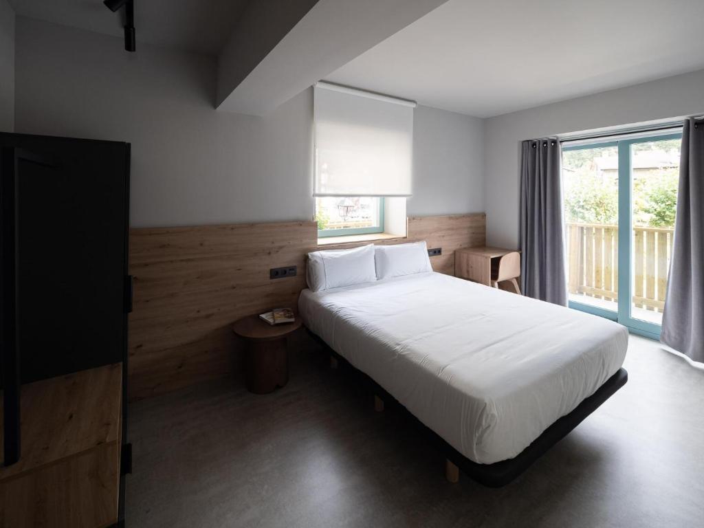 阿拉萨特-蒙德拉贡Casa rural Goiko Errota landetxea的卧室设有白色的床和大窗户