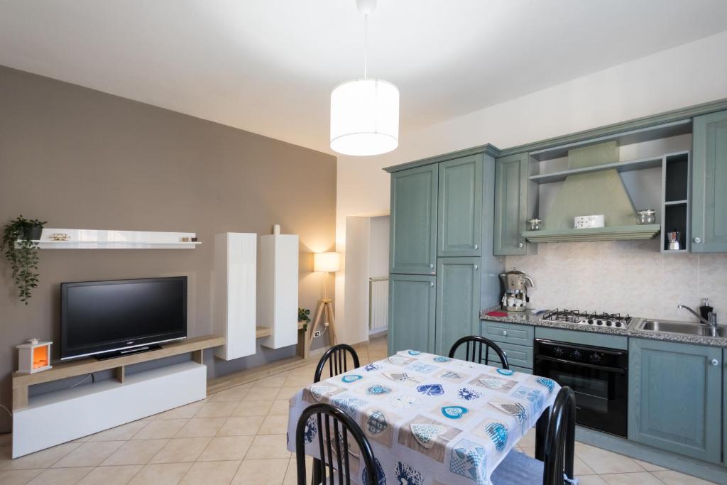 桑格罗堡Appartamento Jacobs的厨房配有绿色橱柜、桌子和电视。