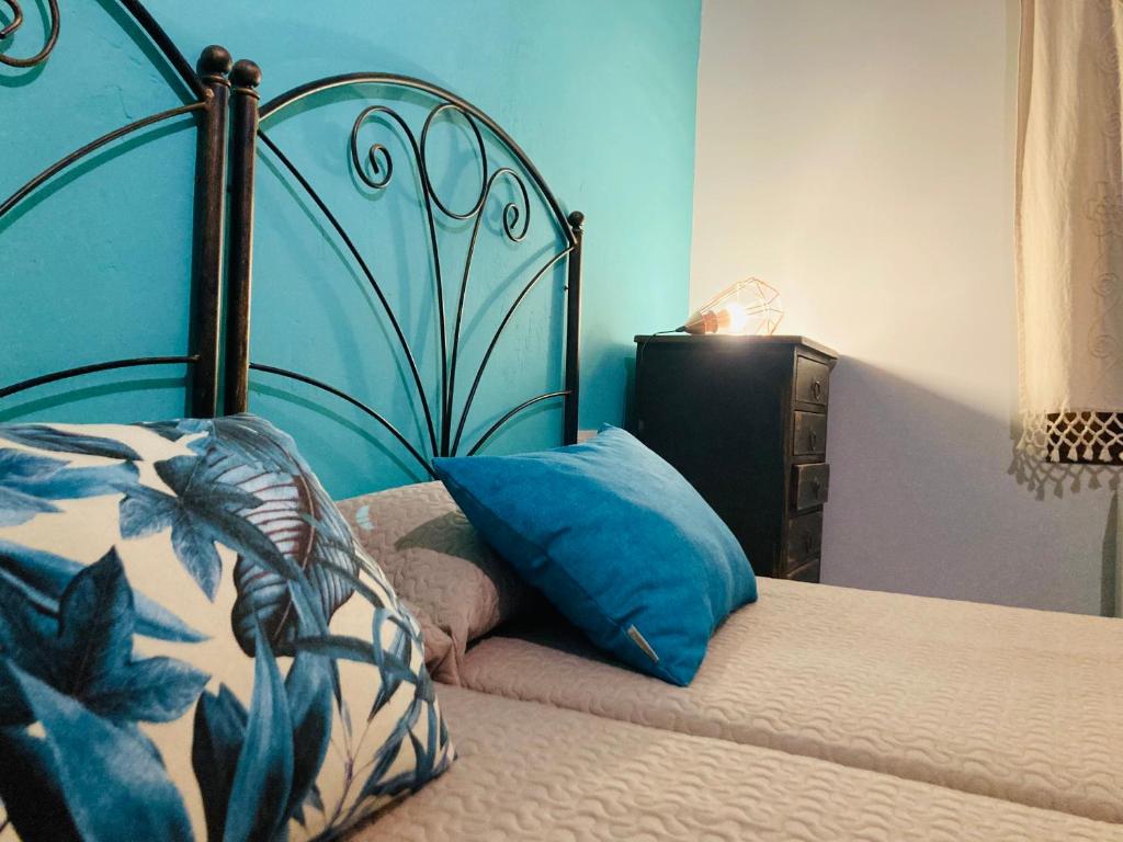 MagallónLoteta Experience的一张带蓝色床头板和枕头的床