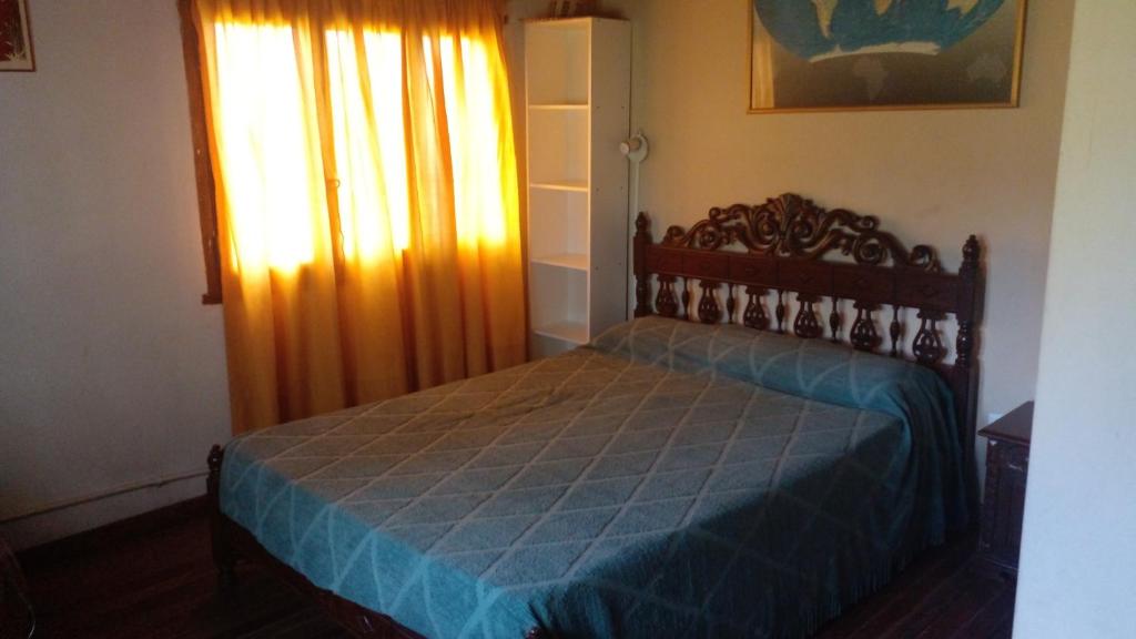 埃塞萨Los Arboles, casa completa a 5 minutos del Aeropuerto Ezeiza的一间卧室配有一张带蓝色棉被的床和窗户。
