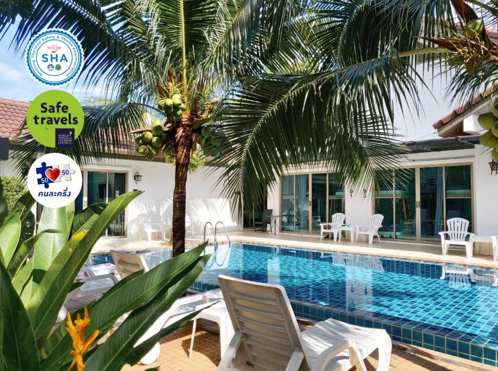 奈扬海滩The Snug Airportel - Phuket Airport的一个带椅子的游泳池,并种植了棕榈树