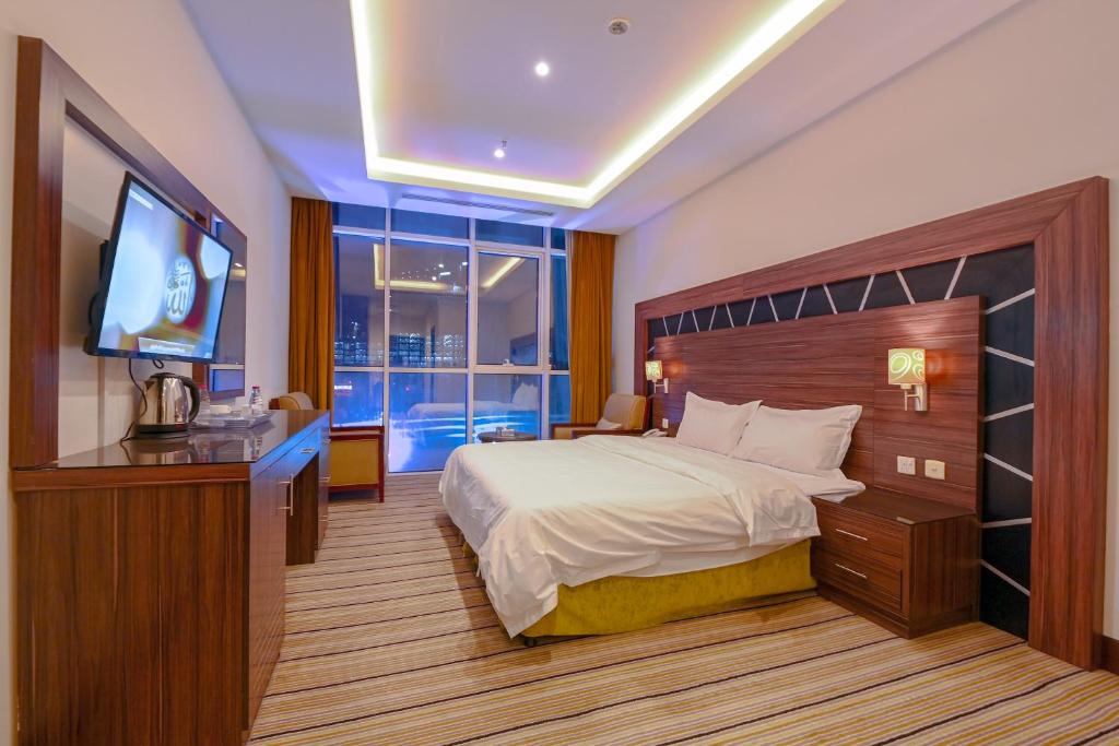 利雅德وحدات دورميرا الفندقيه的配有一张床和一台平面电视的酒店客房
