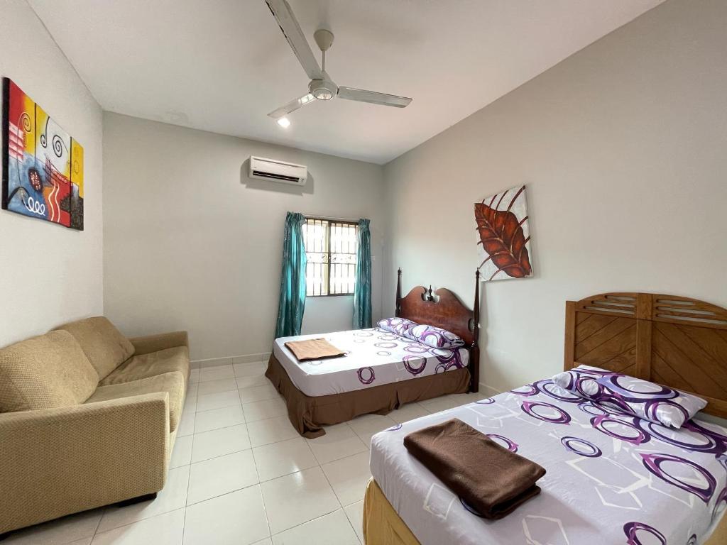 瓜拉丁加奴Near Beach and Airport - Ivana Homestay Unit C1的一间客房内配有床和沙发的房间