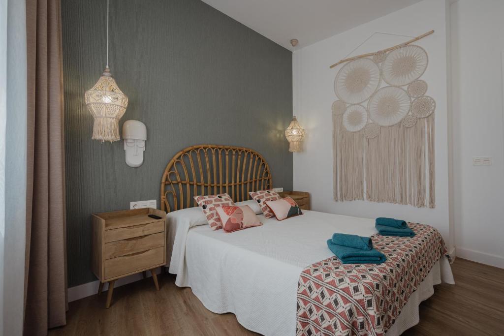 塞博河畔卡莱塔La Pardela Excellence Apartamentos的卧室配有白色的床和木制床头柜。