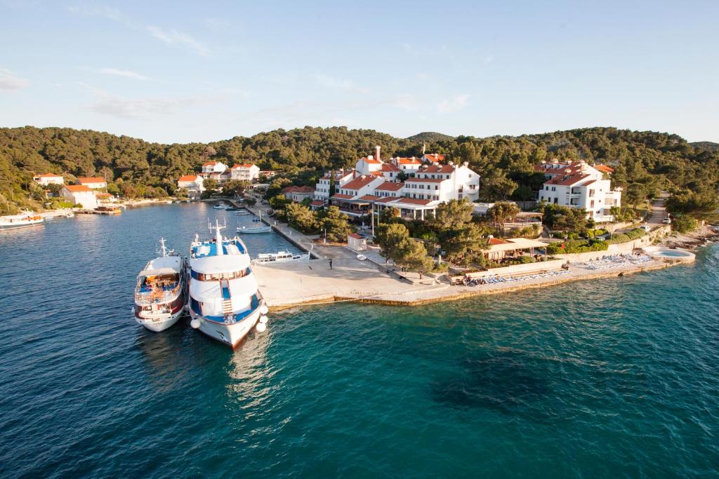 古维达里奥德修斯酒店的两艘船停靠在海滩旁边的水域
