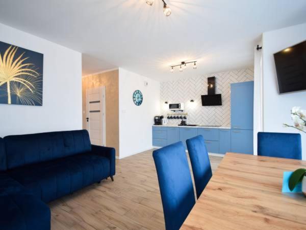 济夫努夫Apartament Navy Blue的客厅配有蓝色的沙发和餐桌