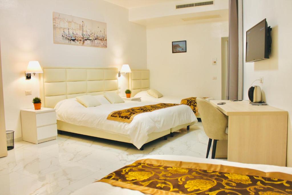 佛罗伦萨Hotel 900 Toscana的酒店客房配有两张床和一张书桌