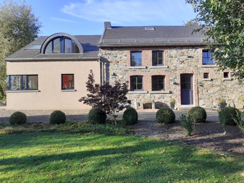 特镇Gîte de Bronromme - villa 5 chambres proche de Spa et Francorchamps的一座大型石头房子,前面有一座庭院
