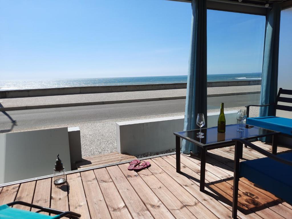 圣伊莱尔德里耶Magnifique appartement face à la mer !! Résidence Charmette的阳台配有桌子,享有海滩美景