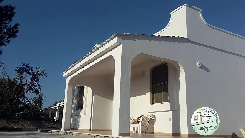 托雷科里梅纳Casa vacanze Villa Franca的前面有椅子的白色建筑